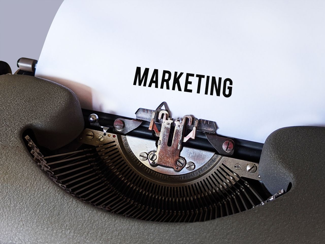 about-02 Close-up of a vintage typewriter with the word 'Marketing' on paper, conveying a retro business theme.