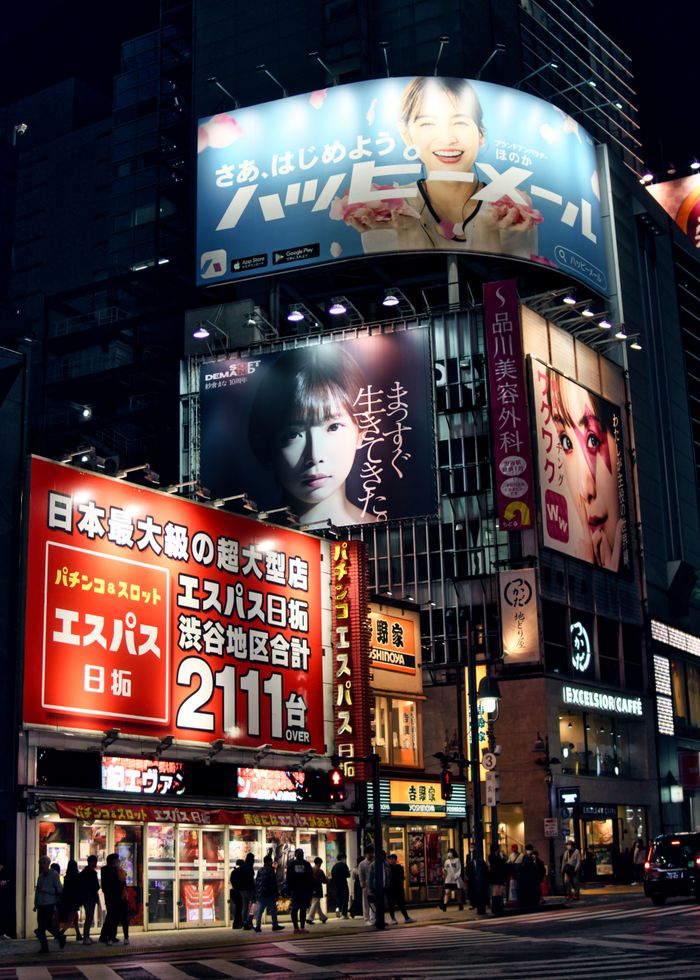Lively Shibuya district in Tokyo captured under colorful neon lights and bustling crowds at night.