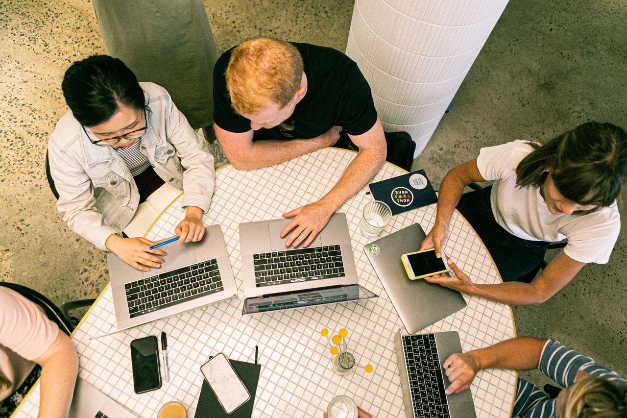 services-01 Top view of diverse team collaboratively working in a modern office setting.