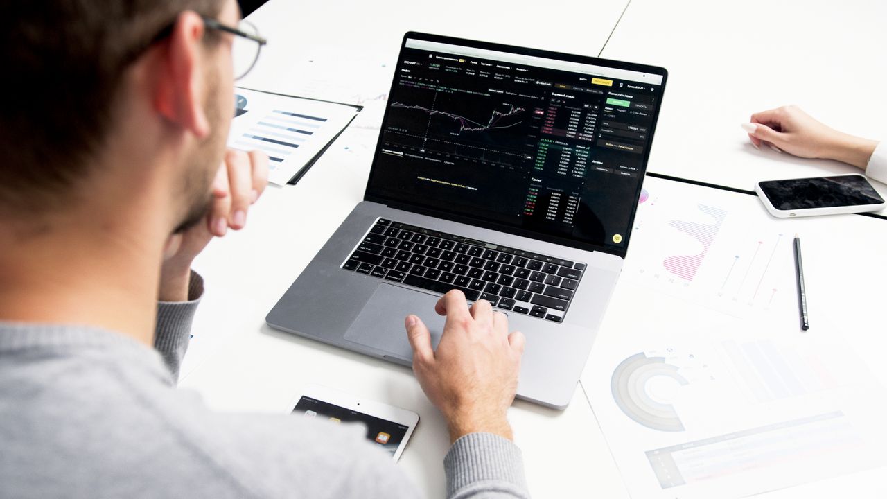 Crafting Captivating Headlines: Your awesome post title goes here Business professional analyzing stock market data on a laptop for investment insights.